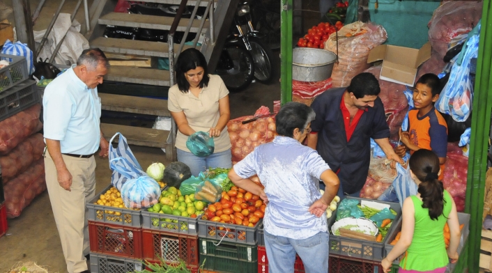 Consumidores en un mercado comprando productos básicos de la canasta familiar