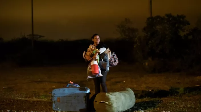 Una migrante venezolana junto a su hijo, vía Panamericana.