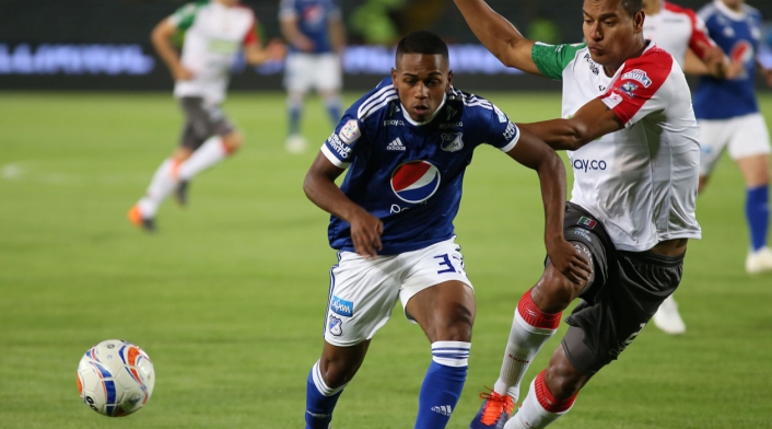Juan Camilo Salazar (Millonarios) disputa el balón con un jugador del Once Caldas