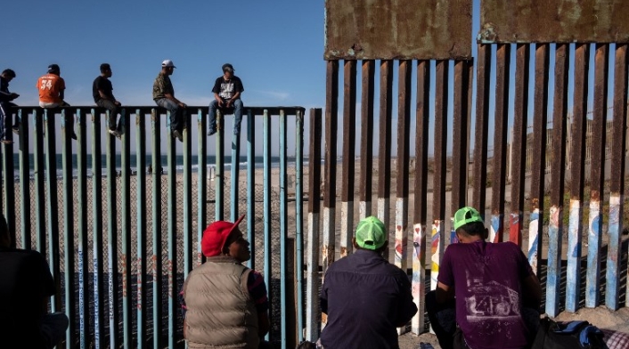 Migrantes centroamericanos en el muro con Estados Unidos