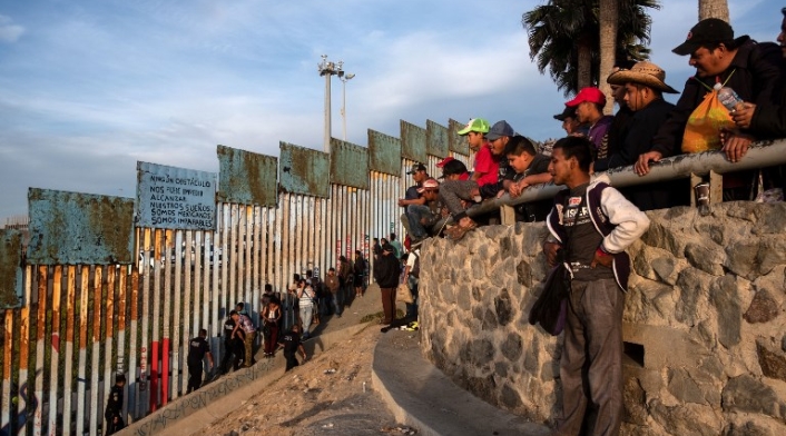 Migrantes centroamericanos en muro de Estados Unidos