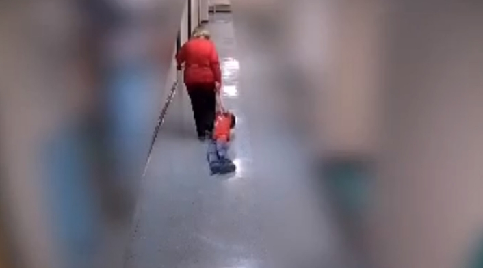 Profesora arrastra a un niño en una escuela