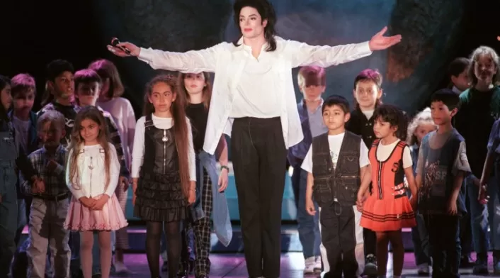Michael Jackson canta junto a niños en un escenario en Mónaco, Francia (1996).
