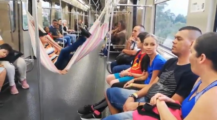 Un hombre cuelga una hamaca en pleno vagón del Metro de Medellín.