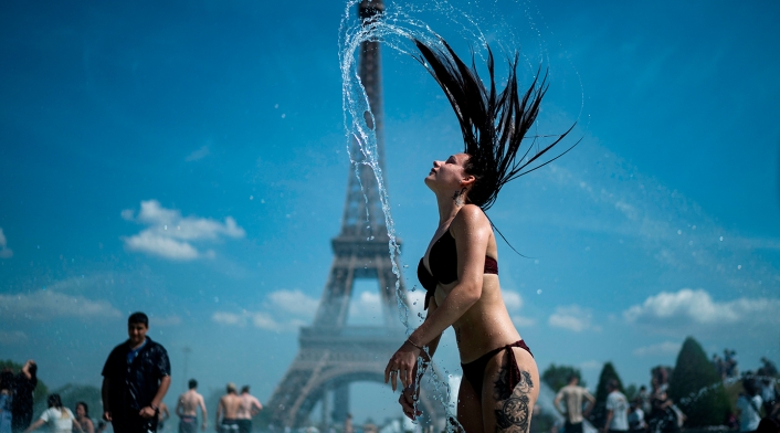 Una mujer se refresca en la fuente de la Plaza del Trocadero, en París, este 25 de junio de 2019, con la Torre Eiffel en el fondo