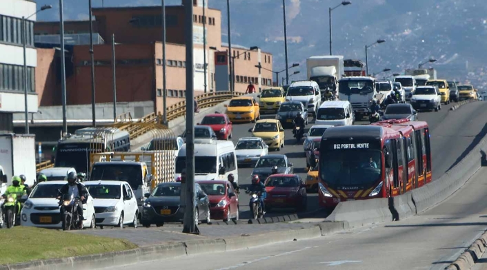 Gente que maneja por vías de uso exclusivo de Transmilenio