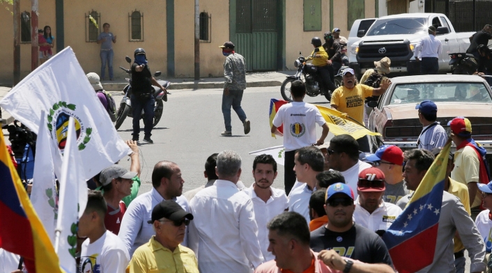 Pistolero apuntando a Juan Guaidó