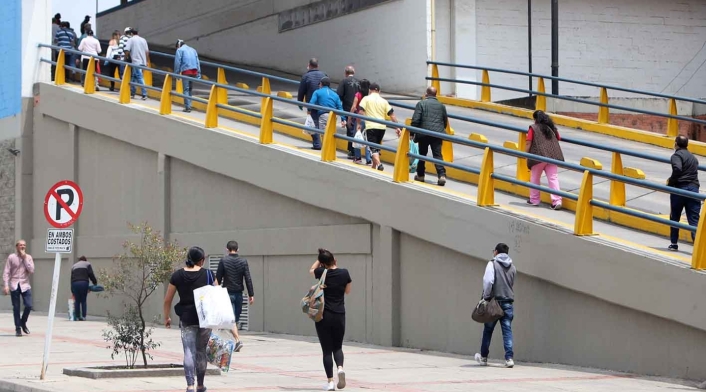 Personas entrando y saliendo de un centro comercial.