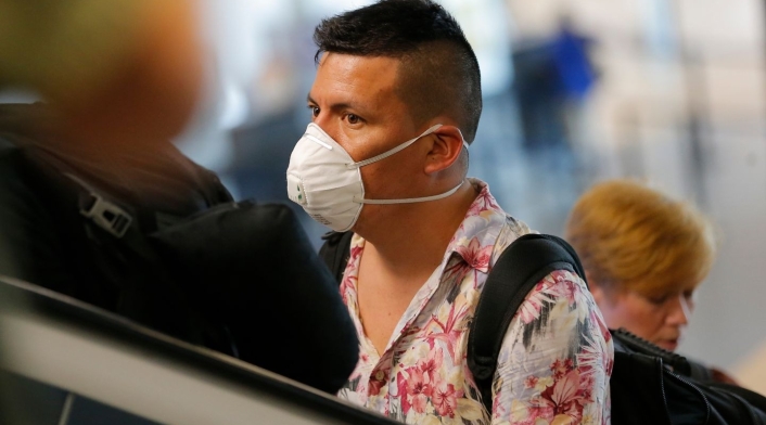 Un hombre usa un tapabocas en aeropuerto