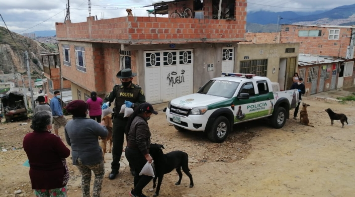 Policía en Bogotá llevando comida a perros y gatos.