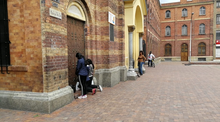 Fieles arrodillados ante las puertas cerradas de la Iglesia del 20 de julio