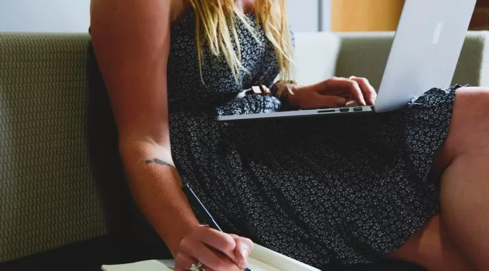 Mujer con computador estudiando