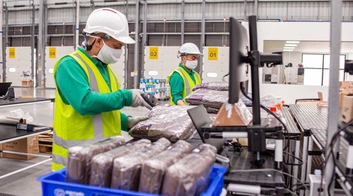 Trabajadores en centro de despacho de Mercado Libre