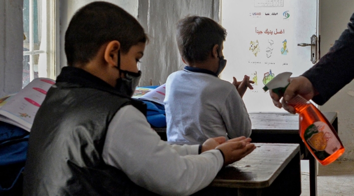 Niños en colegios desinfectándose las manos.