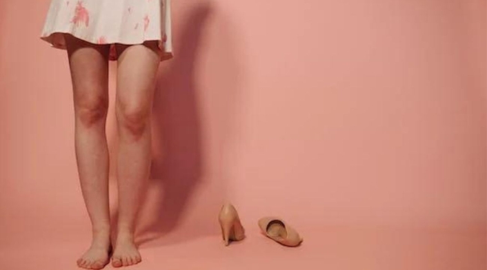 Mujer descalza junto a sus tacones