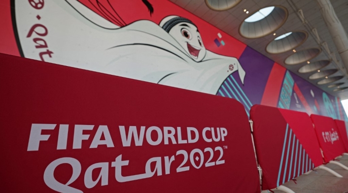 Un muro con el logo de Qatar y La'eeb, la mascota oficial del mundial