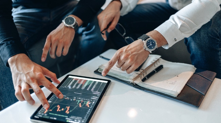 Personas realizan cálculos financieros en una tablet