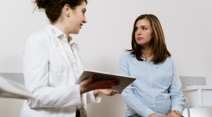 Doctora se encuentra en consulta médica en su despacho con una paciente