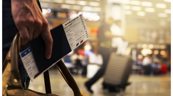 Comprar tiquetes aéreos será más caro en 2023 Persona con tiquete de viaje