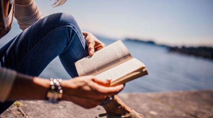 mujer con un libro en sus manos leyendo