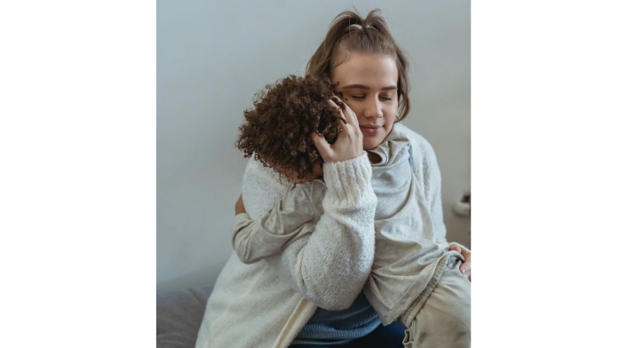 Mujer abrazando a un niño Mujer sentada abrazando a un niño