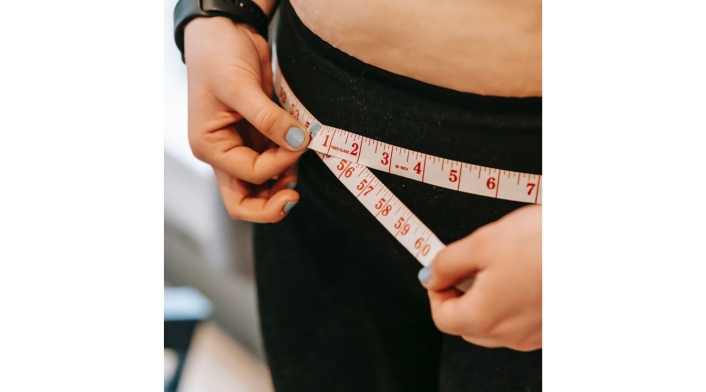 Sobre peso: por qué es malo comer frente a las pantallas Persona midiendo sus caderas: por qué es malo comer frente a las pantallas