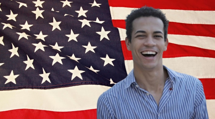Cita para la Visa Americana Bandera de Estados Unidos y hombre latino sonriendo