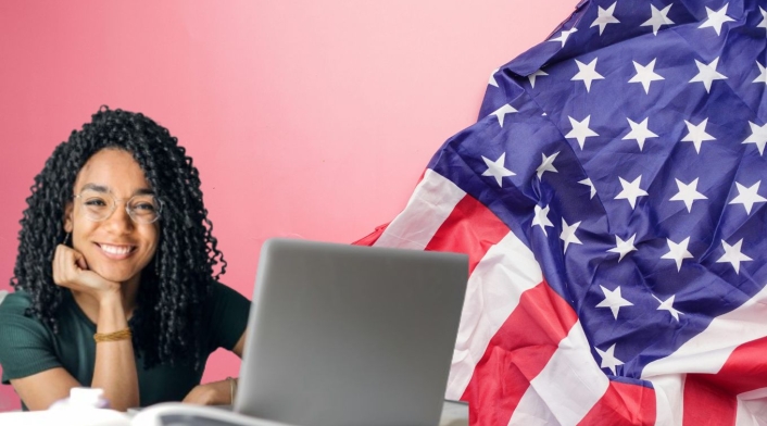 Trabajo en Estados Unidos para personas que hablen español Bandera de Estados Unidos y una mujer con un computador