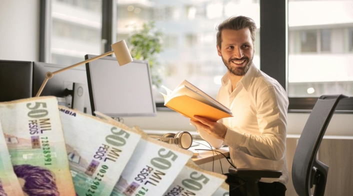 Vacantes de empleo con el Distrito: no piden experiencia Persona en un escritorio trabajando y billetes