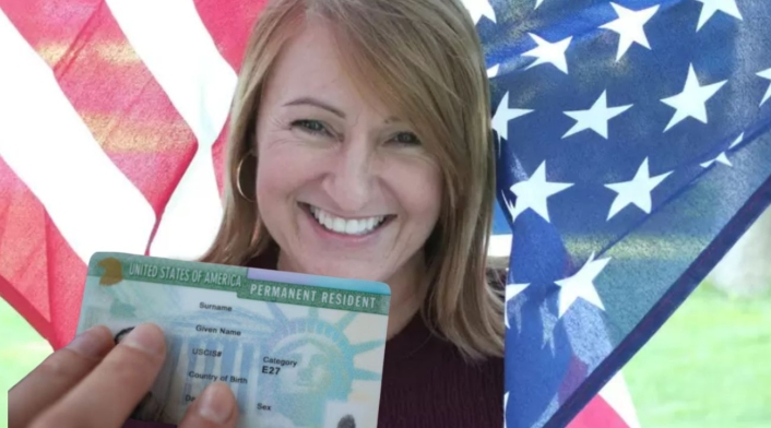 Trabajo para colombianos en Estados Unidos: dan green card Mujer con la bandera de Estados Unidos