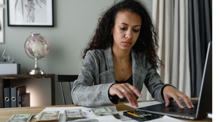 Declaración de renta en Colombia Mujer con billetes y calculadora