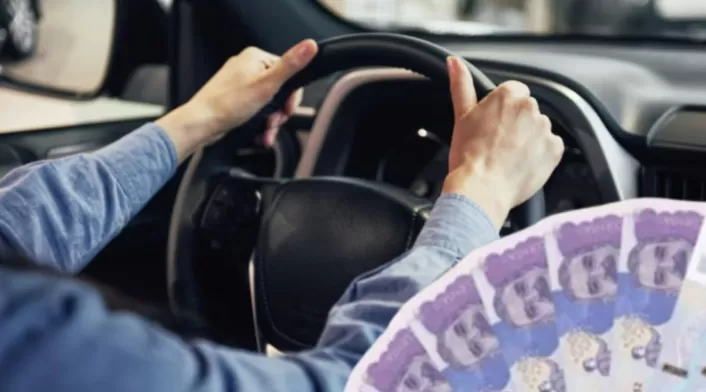 Remate de carros en Colombia: vehículos desde los $11millones Una persona manejando y billetes