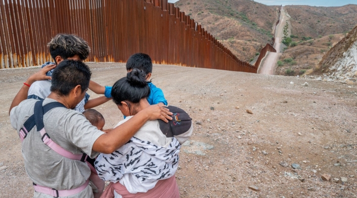 Una familia migrante que busca asilo desde Ecuador reza al lado de la frontera Una familia migrante que busca asilo desde Ecuador reza al lado de la frontera