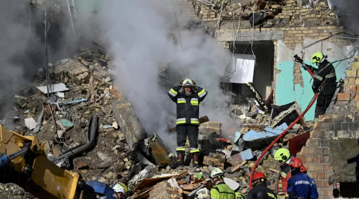 Rescatistas atienden en un edificio destruido la emergencia que provocó un ataque de Rusia a Kiev.