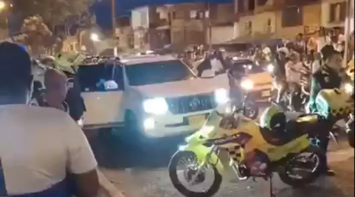 Captura de pantalla de un video difundido en redes sociales que muestra a una camioneta de alta gama afectada por disparos e inspeccionada por la Policía y por testigos.