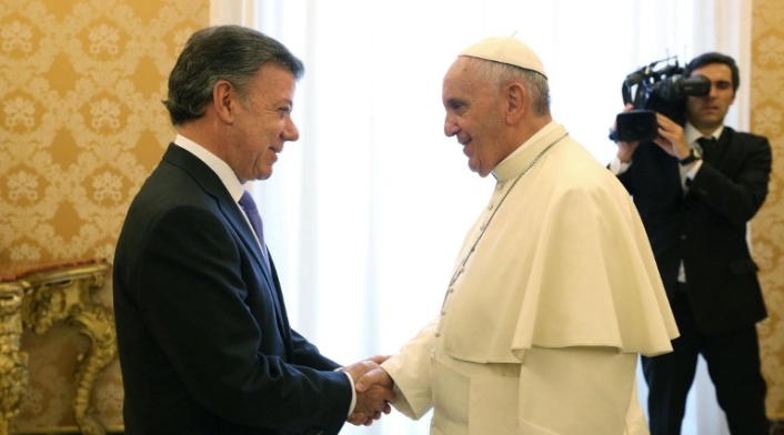 Pope Francis (R) shakes hands with Colombia's President, Juan Manuel Santos Calderon, during their private audience in Vatica...