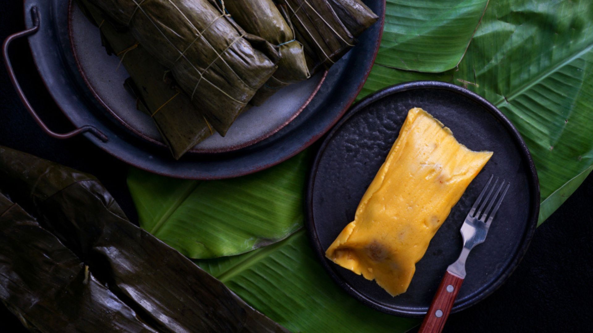 Ensamble del tamal tolimense con masa, carnes y vegetales antes del amarre final.