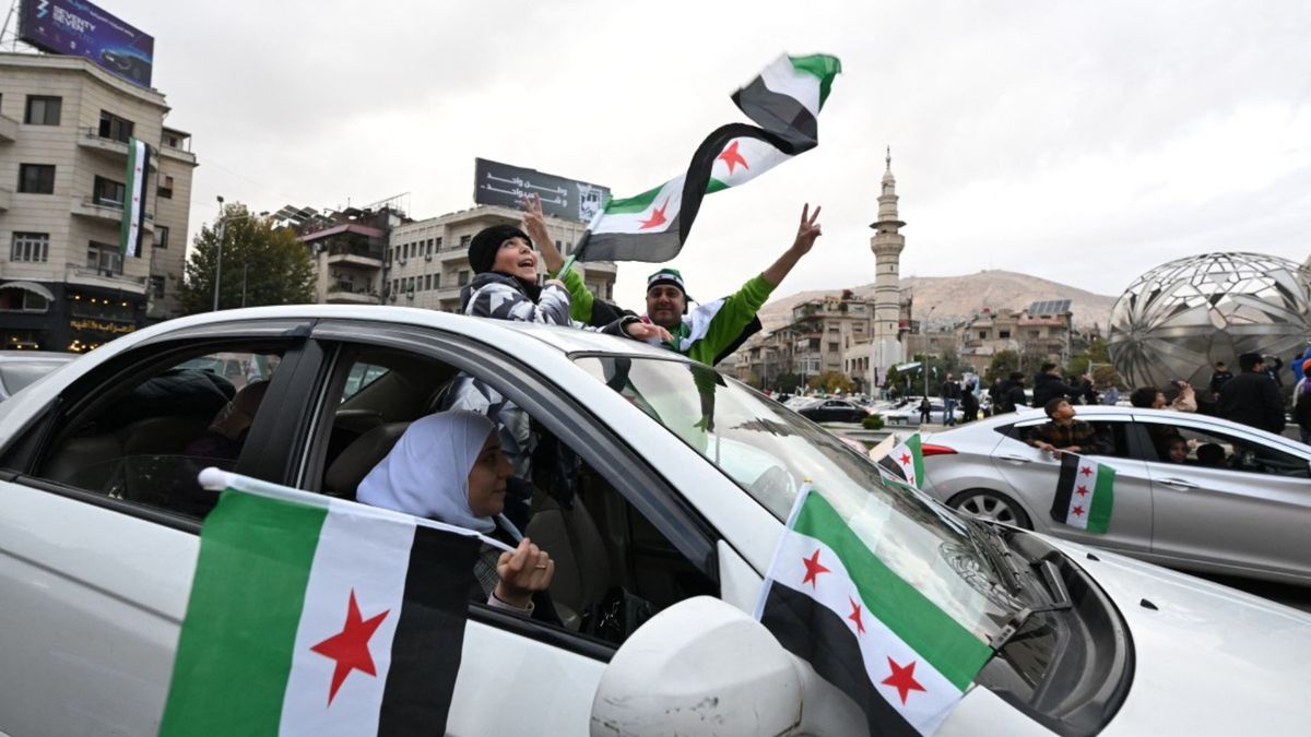 A lo largo de la mañana, columnas de personas llegaron al emblemático punto de encuentro en Damasco portando bengalas, pancartas y música entre los edificios.