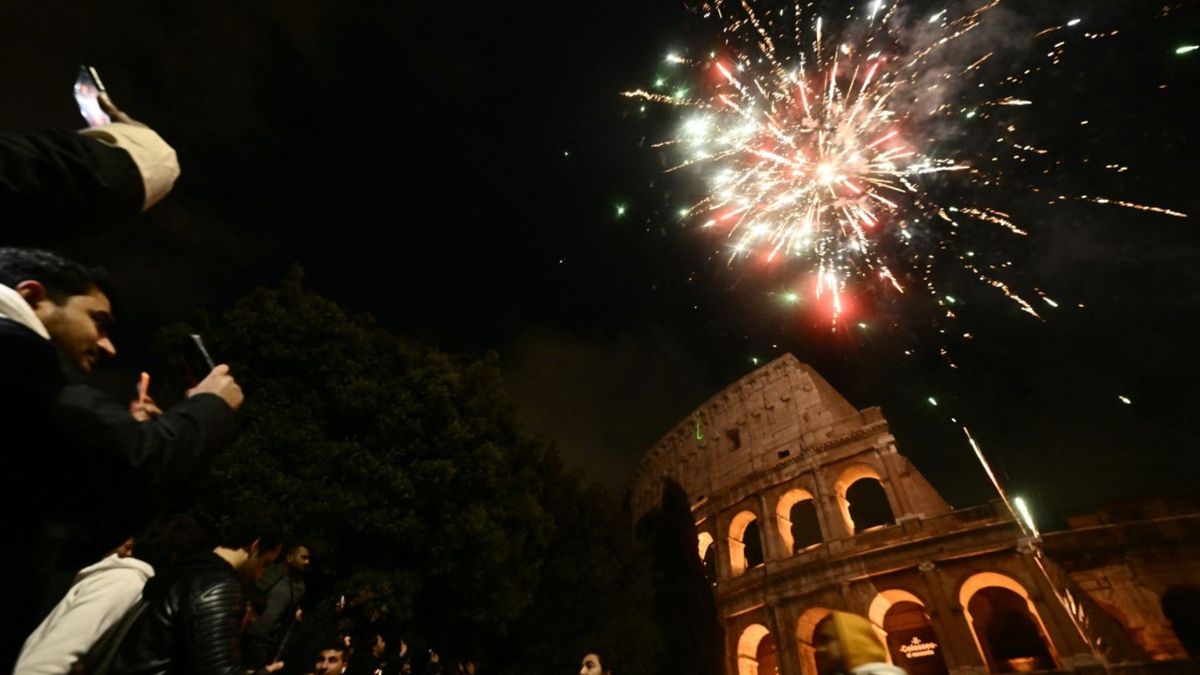 Las personas se reúnen durante las celebraciones de Año Nuevo frente al Coliseo, en el centro de Roma.