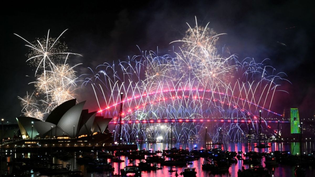 Fuegos artificiales iluminan el cielo de medianoche sobre el Puente de la Bahía de Sídney y la Ópera de Sídney