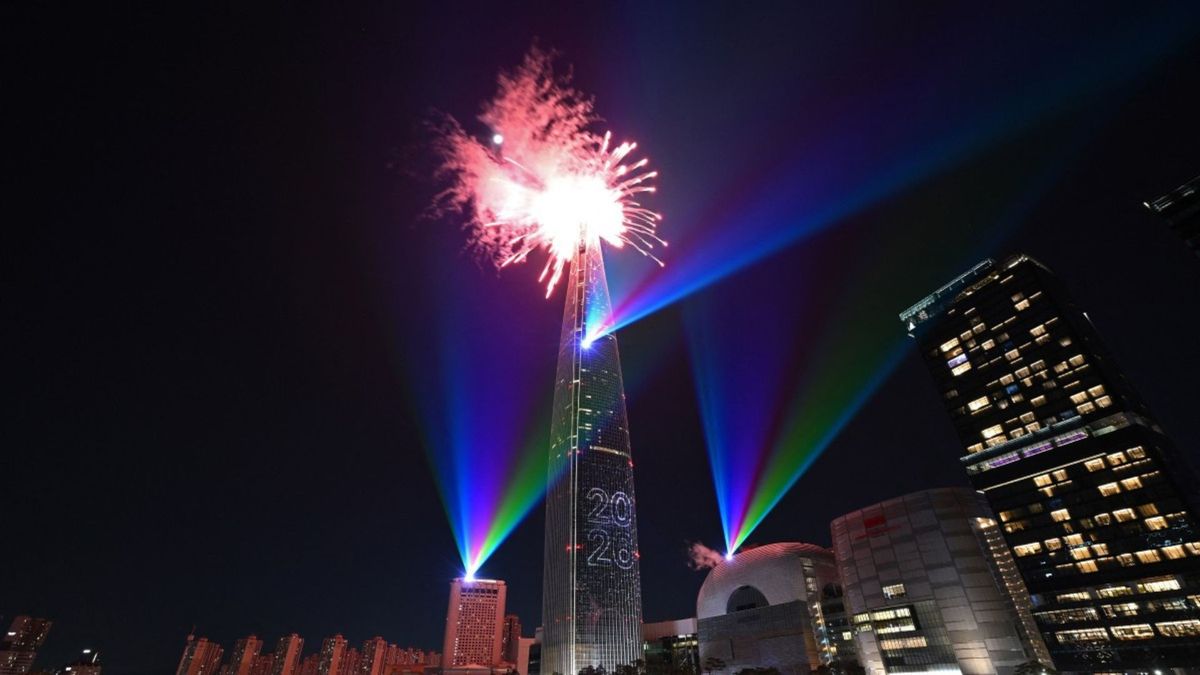 Luces láser iluminan el cielo de medianoche sobre la Torre Lotte World, el edificio más alto de Corea del Sur, en Seúl, durante las celebraciones del Año Nuevo.