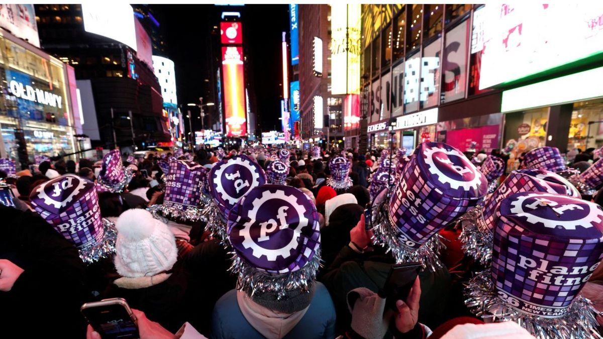 Los asistentes posan mientras celebran la víspera de Año Nuevo en Times Square. Select 80 more words to run Humanizer.