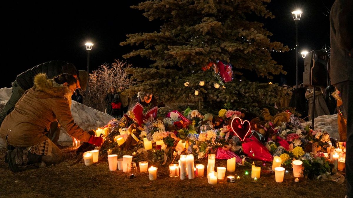Un miembro de la comunidad coloca flores en un monumento conmemorativo durante una vigilia con velas por las víctimas de la escuela secundaria Tumbler Ridge, donde se produjo un tiroteo masivo el día anterior, en el pequeño pueblo de Tumbler Ridge, Columbia Británica, el 11 de febrero de 2026.