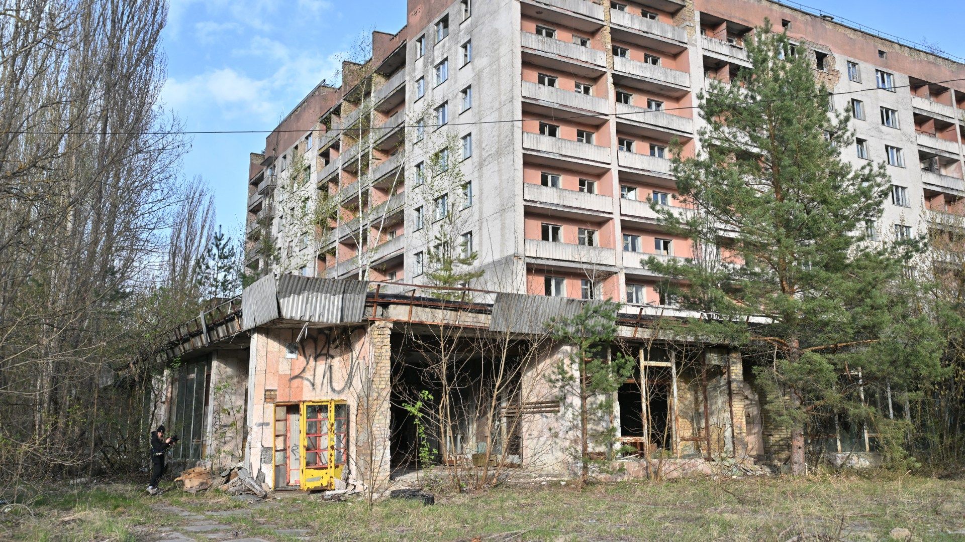 Un visitante toma una foto frente a un edificio residencial abandonado en la ciudad fantasma de Prípiat, cerca de la central nuclear de Chernóbil.