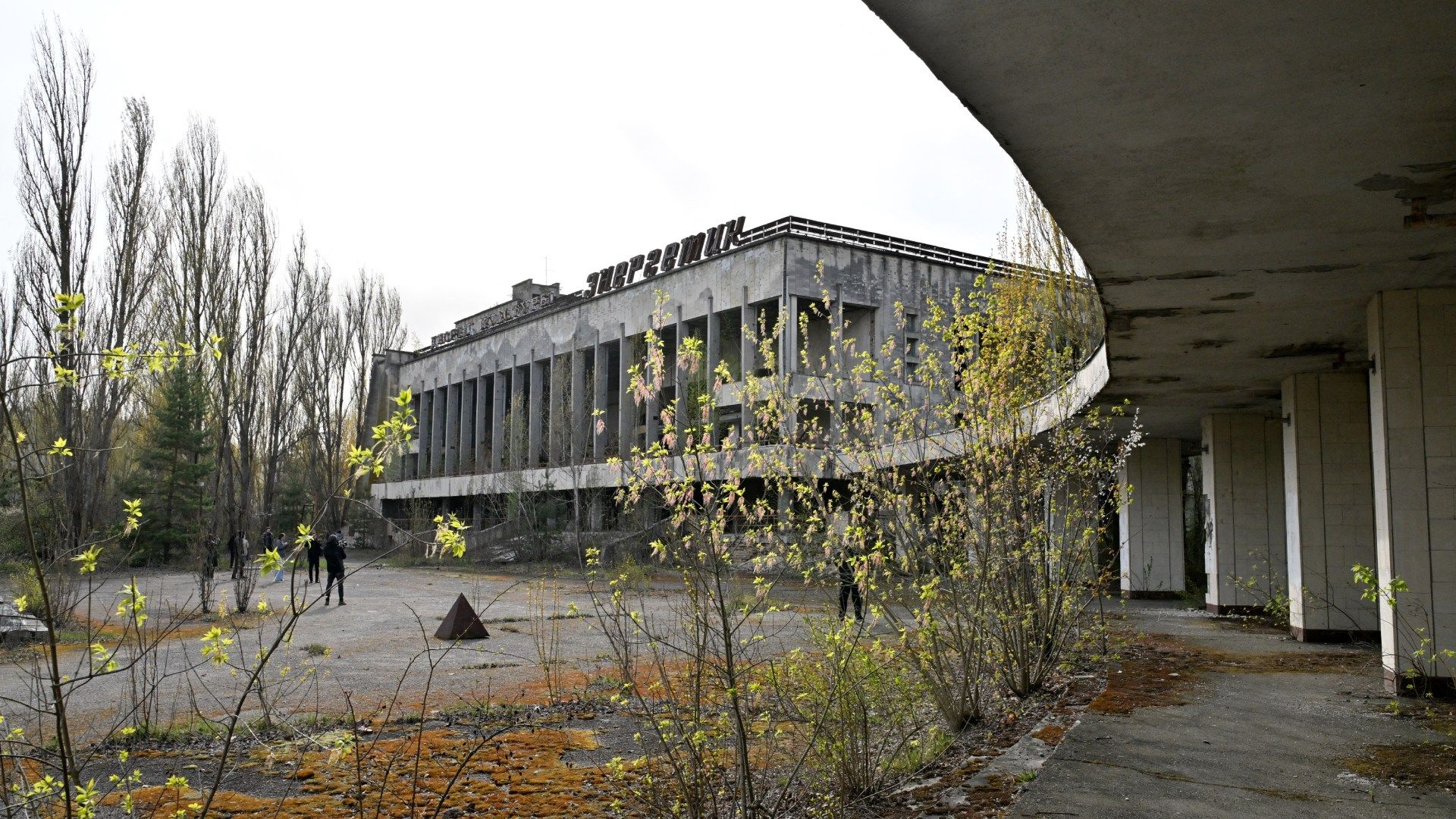 Visitantes se encuentran frente al abandonado Palacio de la Cultura Energetik en la ciudad fantasma de Prípiat, cerca de la central nuclear de Chernóbil.