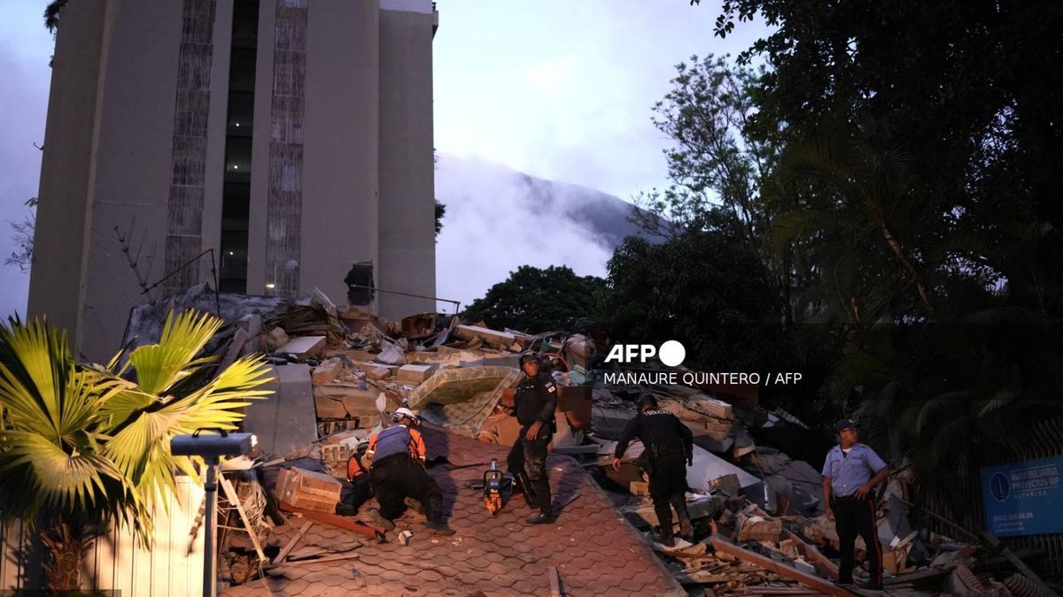 Hombres reaccionan frente a un edificio derrumbado tras el terremoto en Caracas