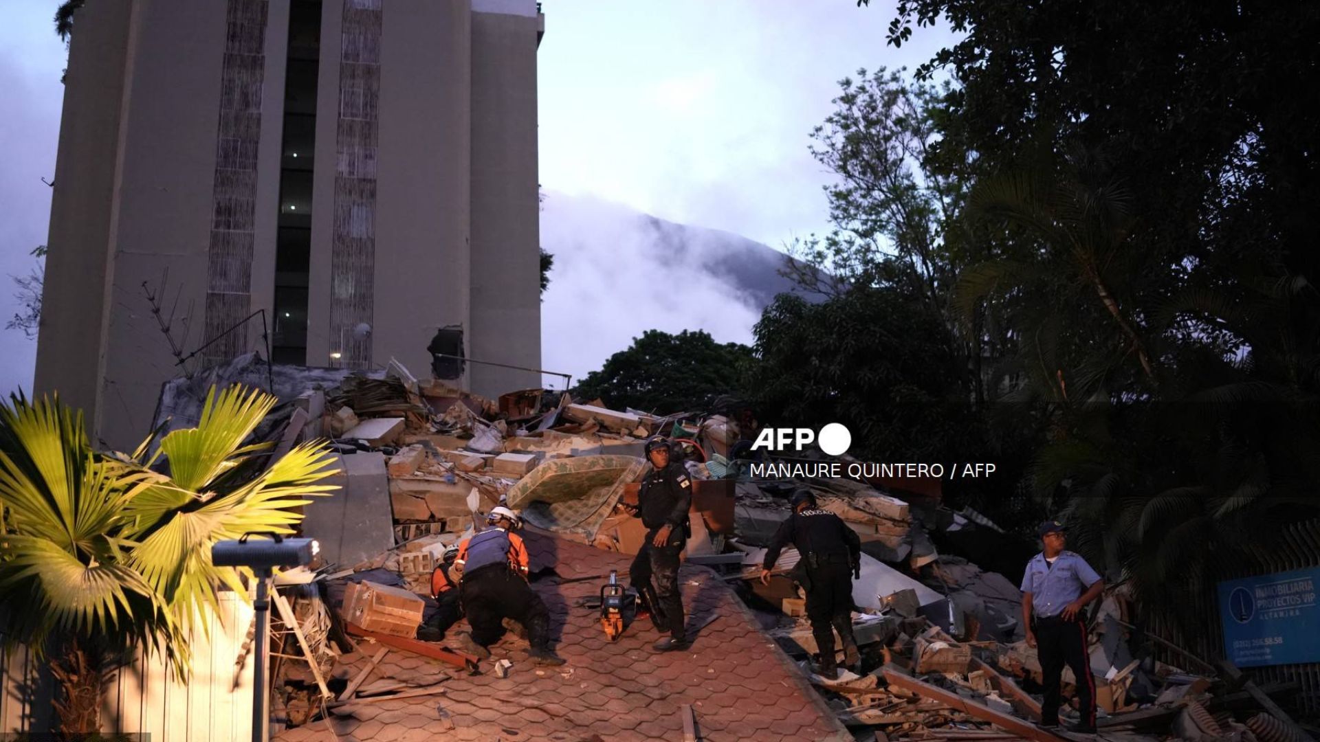 Hombres reaccionan frente a un edificio derrumbado tras el terremoto en Caracas