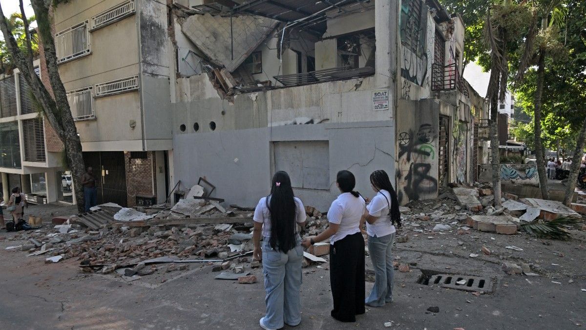 Dos mujeres observan un edificio colapsado en Cali, Colombia, tras sismo de 7.4