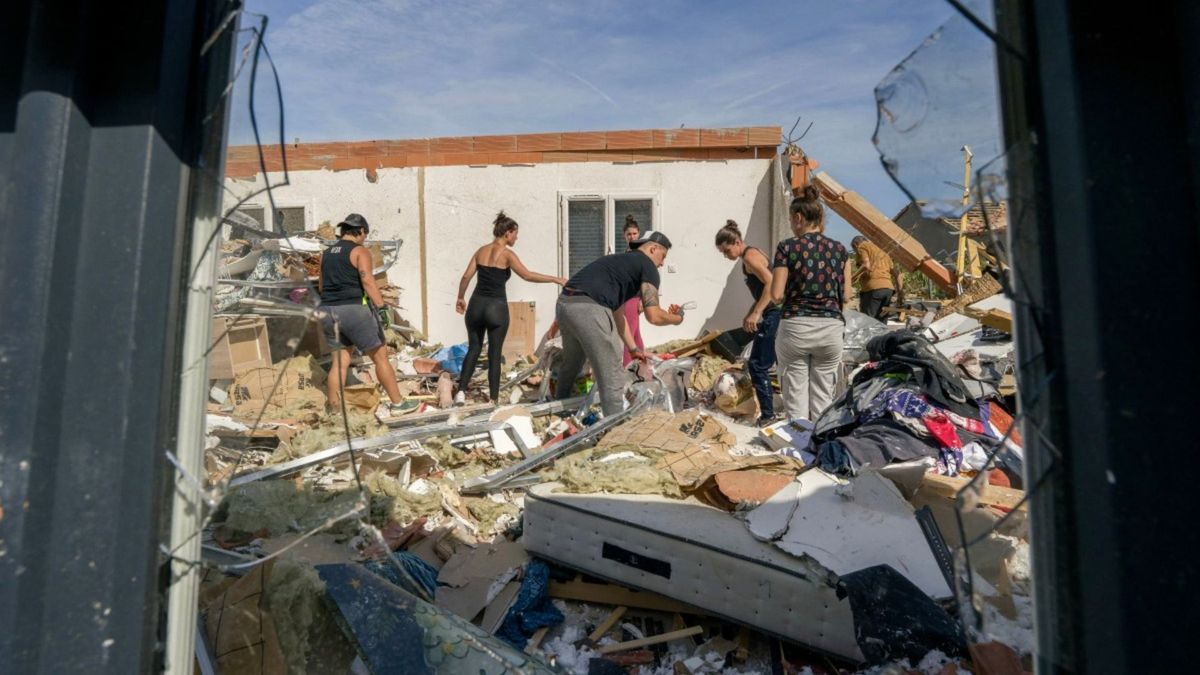 Varias personas limpian los escombros de una casa dañada tras el paso de un tornado en Pomas, en el suroeste de Francia.