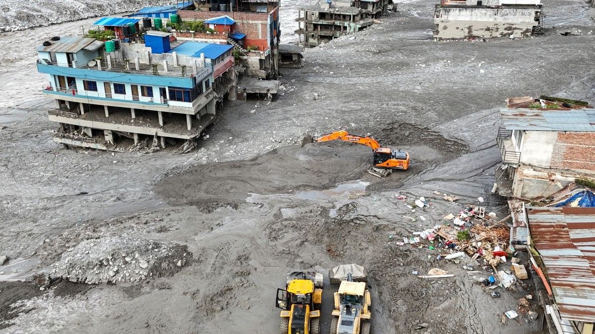 Trabajadores utilizando excavadoras para retirar el lodo tras las inundaciones repentinas en Trishuli, en el distrito de Nuwakot de Nepal
